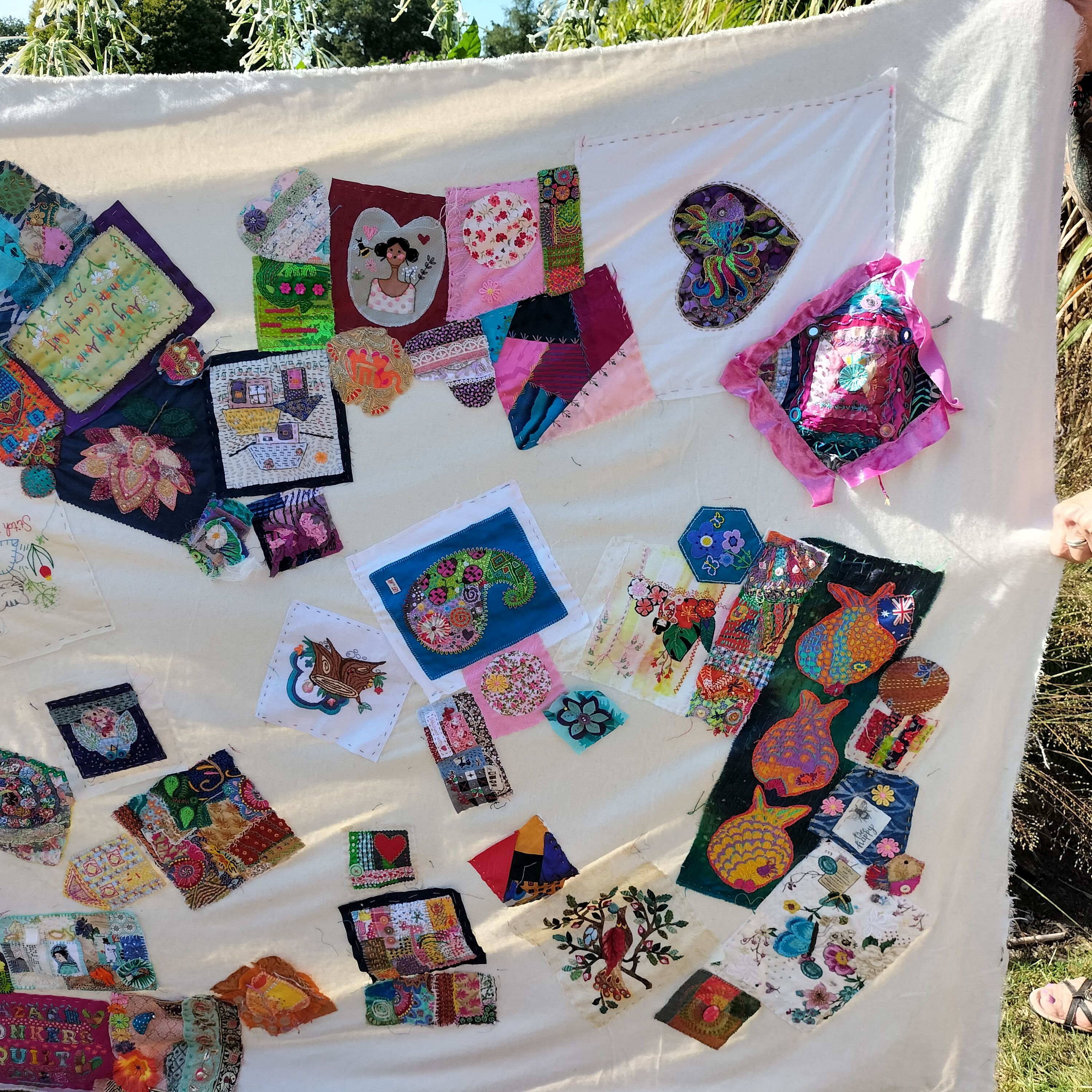 The other end of the quilt, with more colourful patches stitched onto the neutral background.