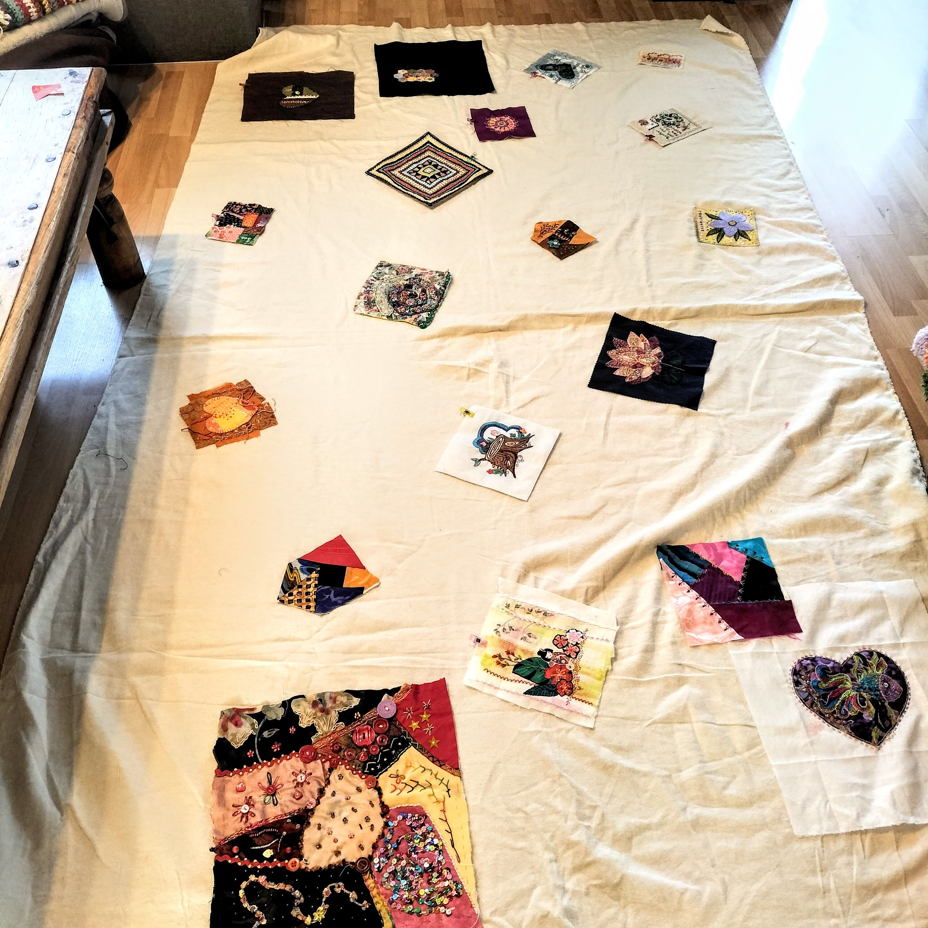 A large piece of cotton interlining, with some colourful patches stitched onto it