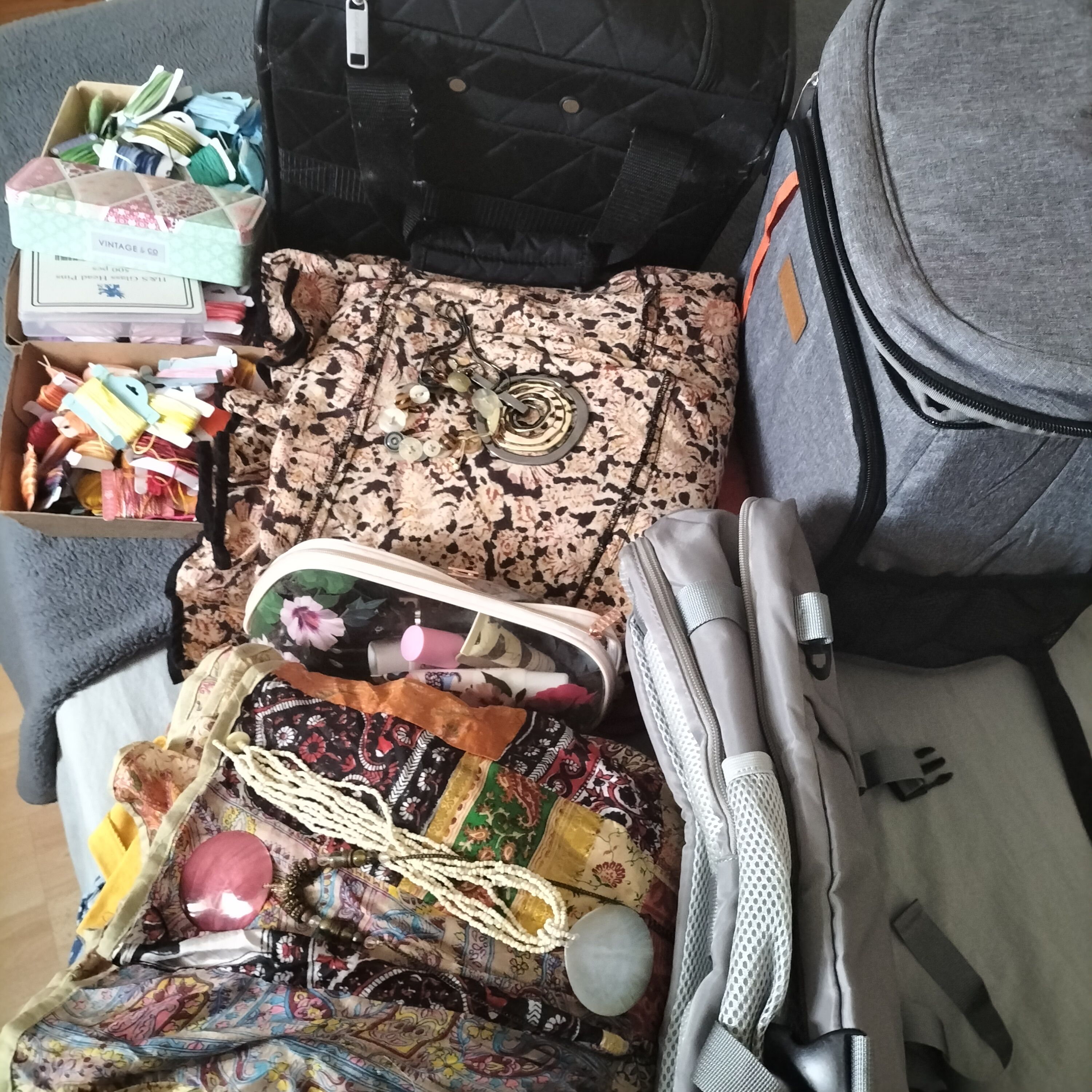 Several bags stuffed with clothes and threads